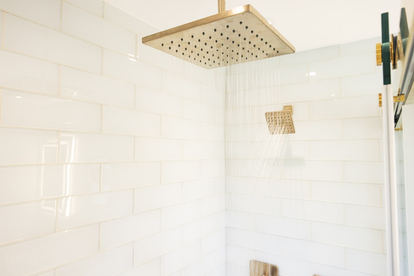 Gold rain shower with white subway tile