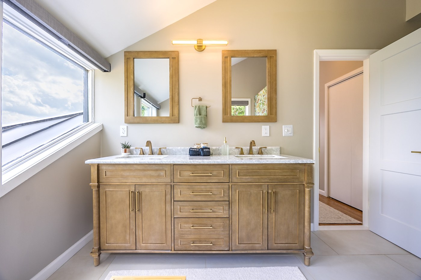 Double vanity with skylight and brass fixtures
