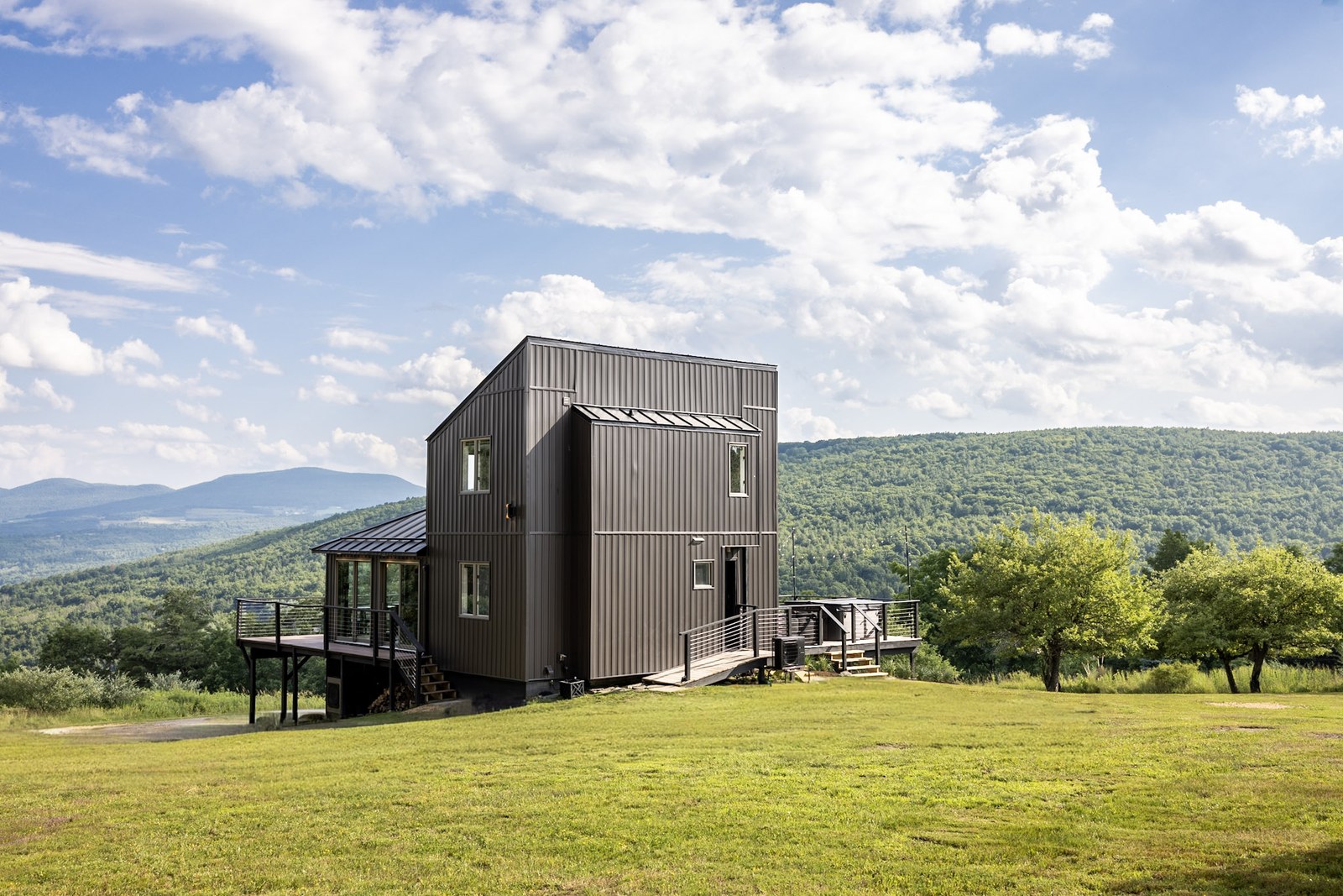 Second angle of Hollow Sky exterior — dark paneling, hillside setting, mountain views